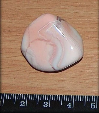 Pink-white agate from Botswana beside a ruler
