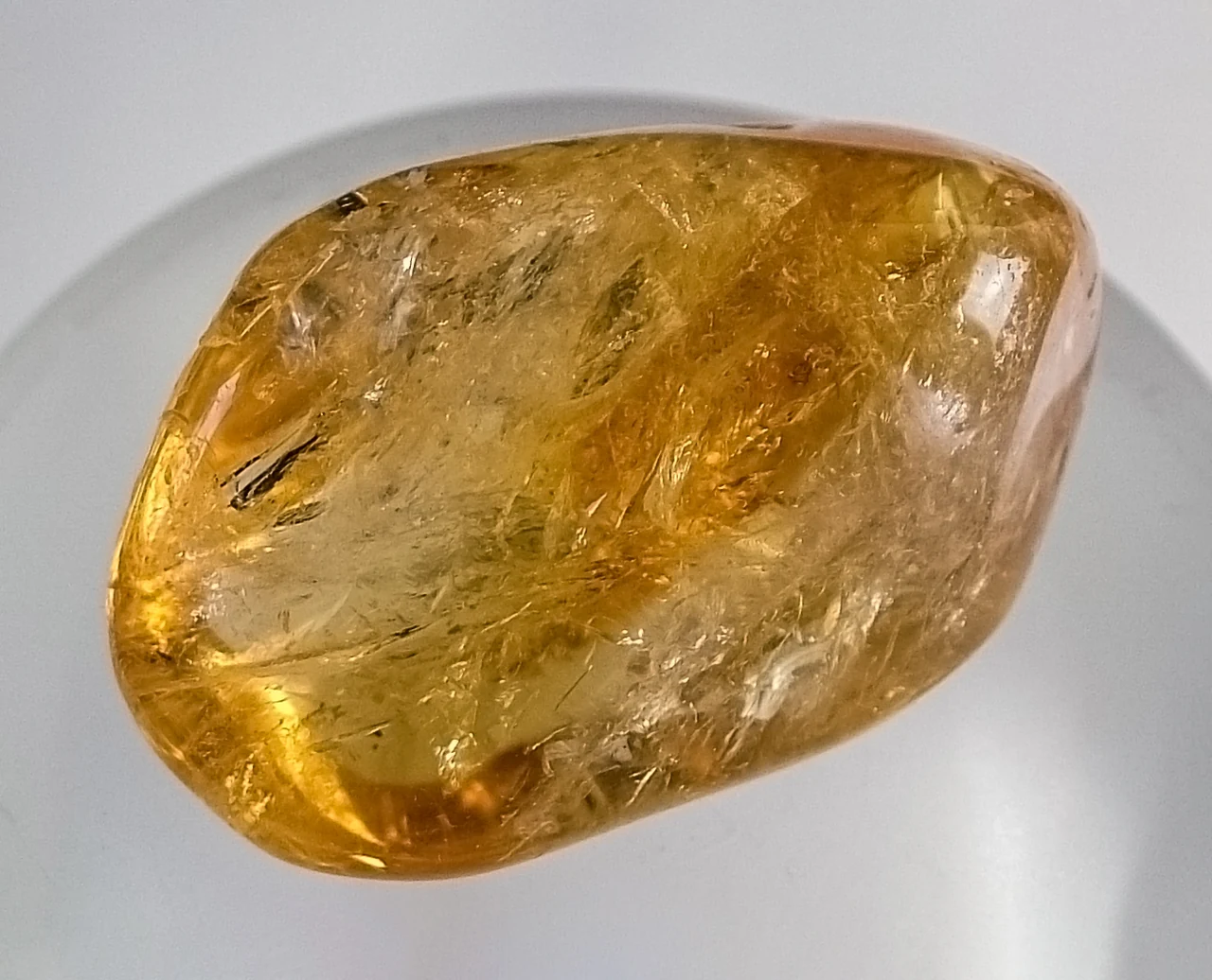 Golden yellow tumbled citrine with visible internal fractures.