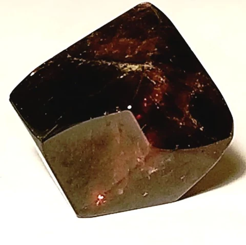 Polished garnet with a dark red interior and shiny surfaces.