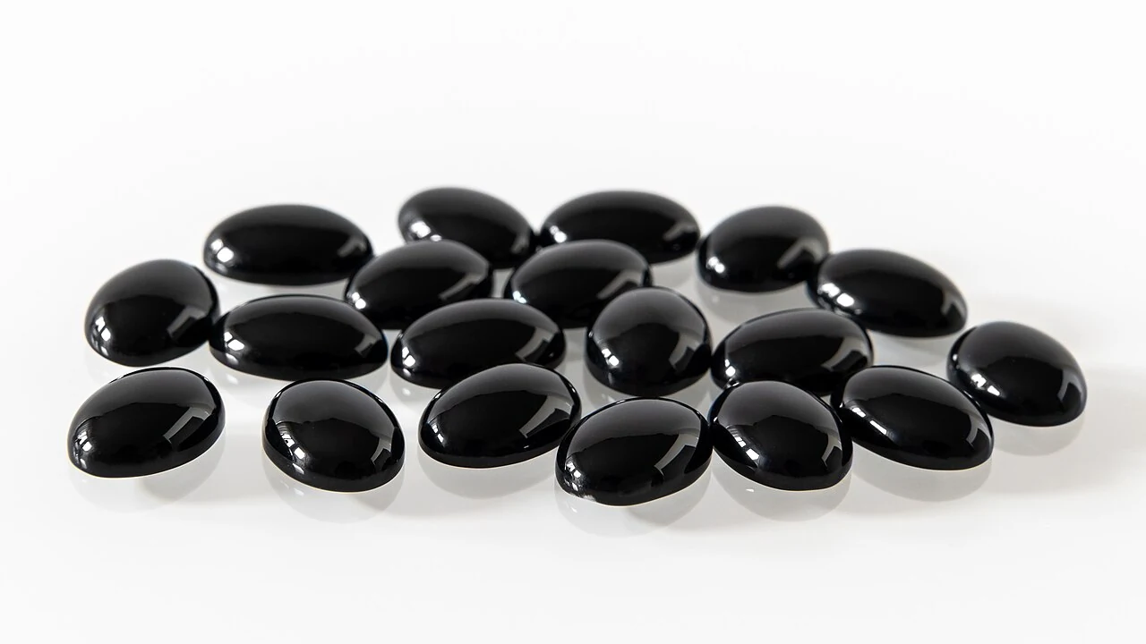Black oval cabochons described as onyx