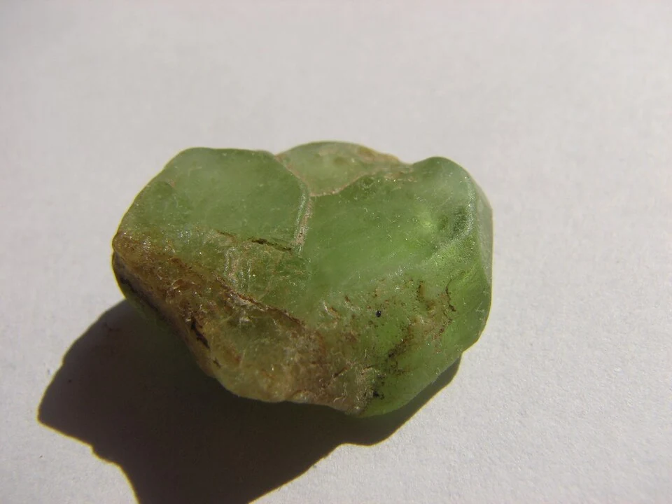 Small rough peridot from Pakistan on a light background