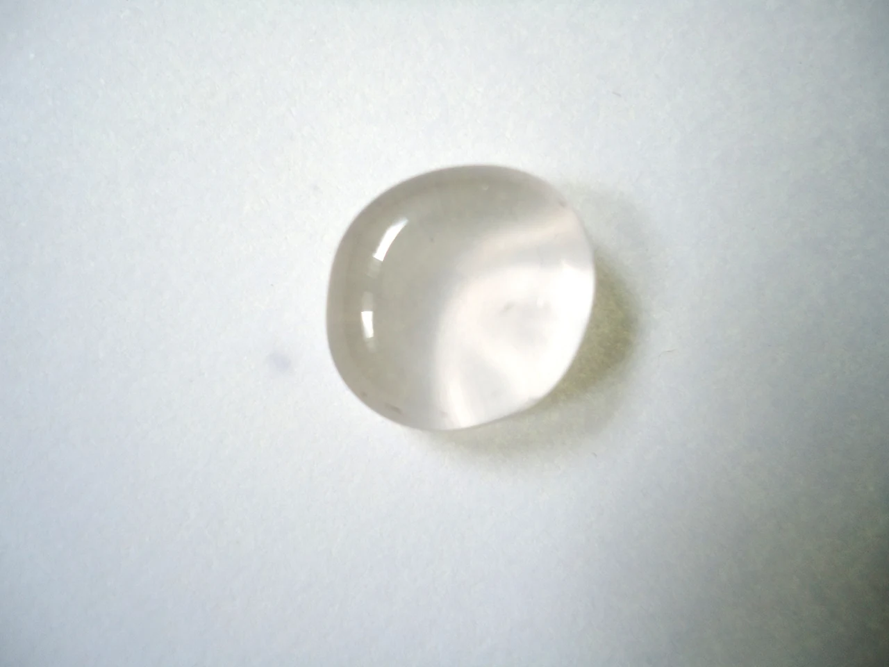 Polished colourless quartz pebble with a rounded surface.