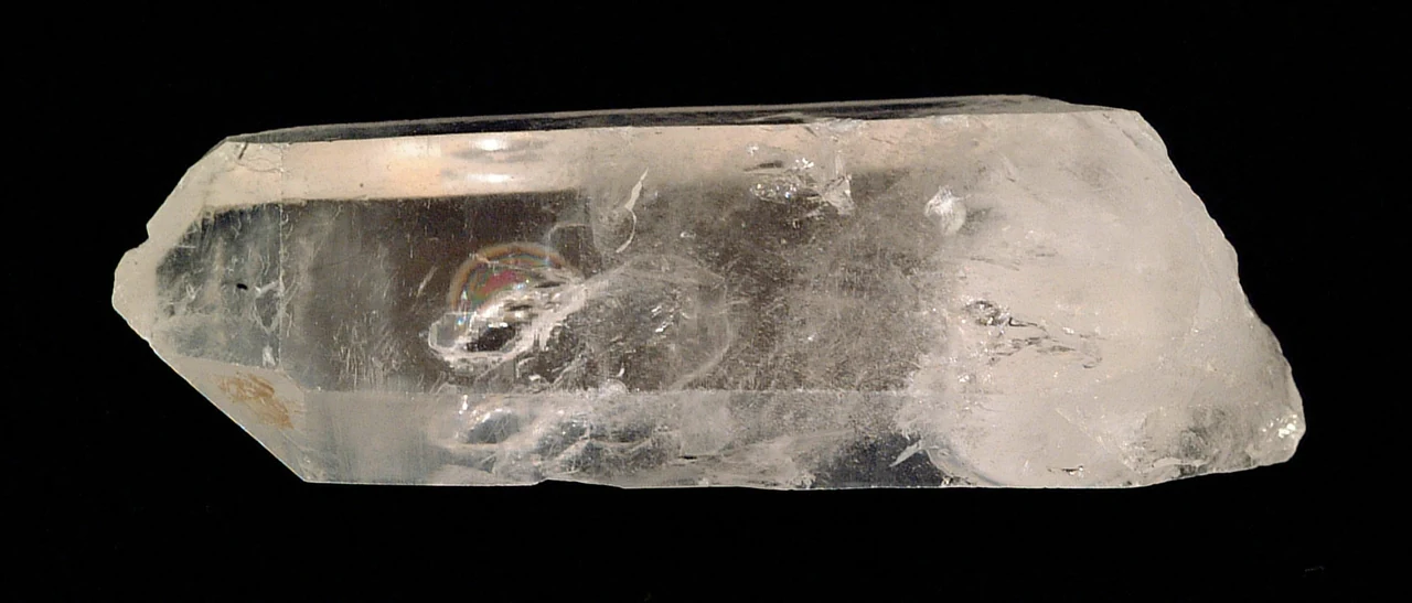 Natural colourless quartz crystal with a visible termination and internal fractures.