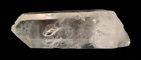 Natural colourless quartz crystal with a visible termination and internal fractures.