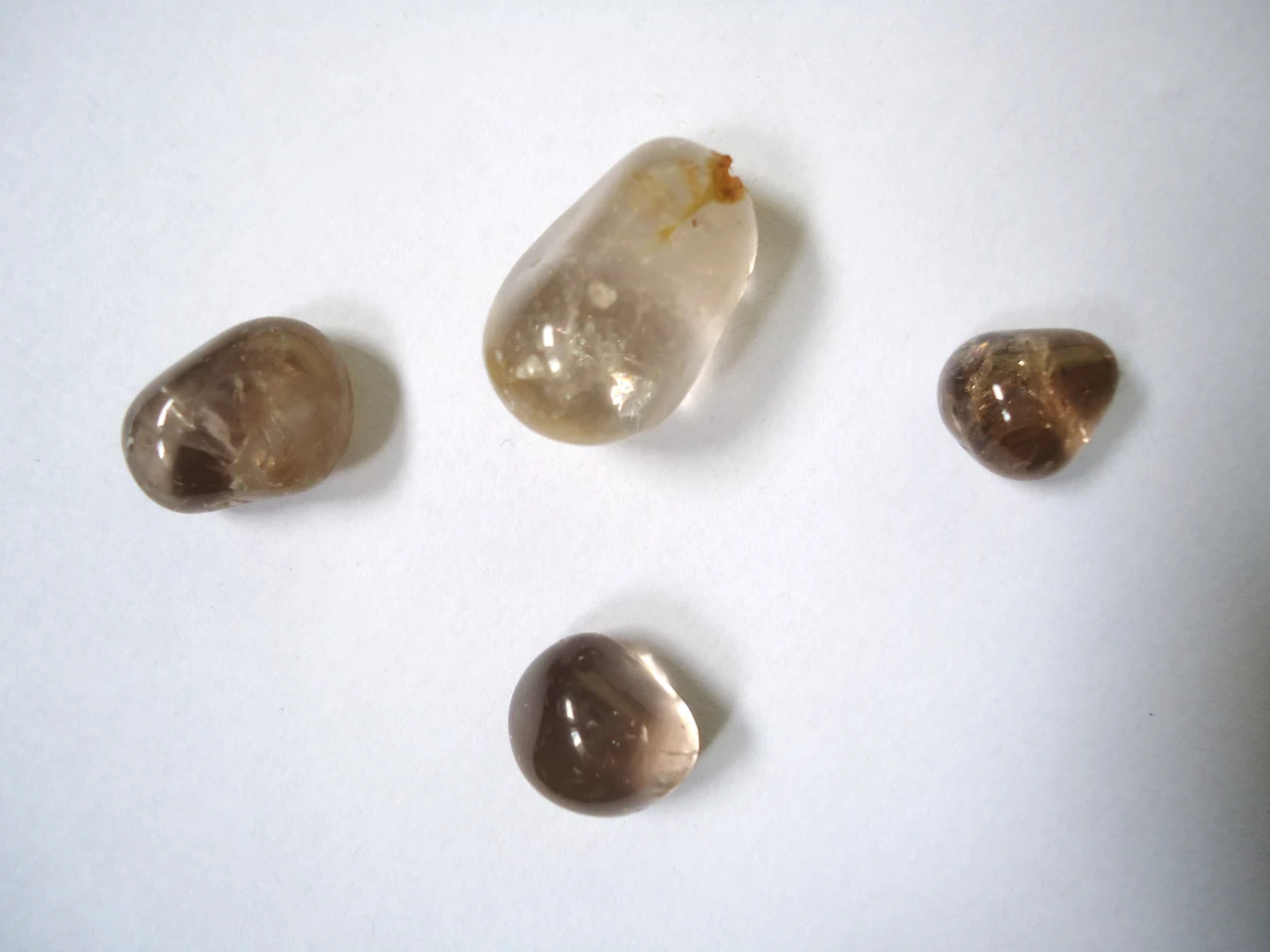 Polished smoky quartz pebbles in varying brown tones.