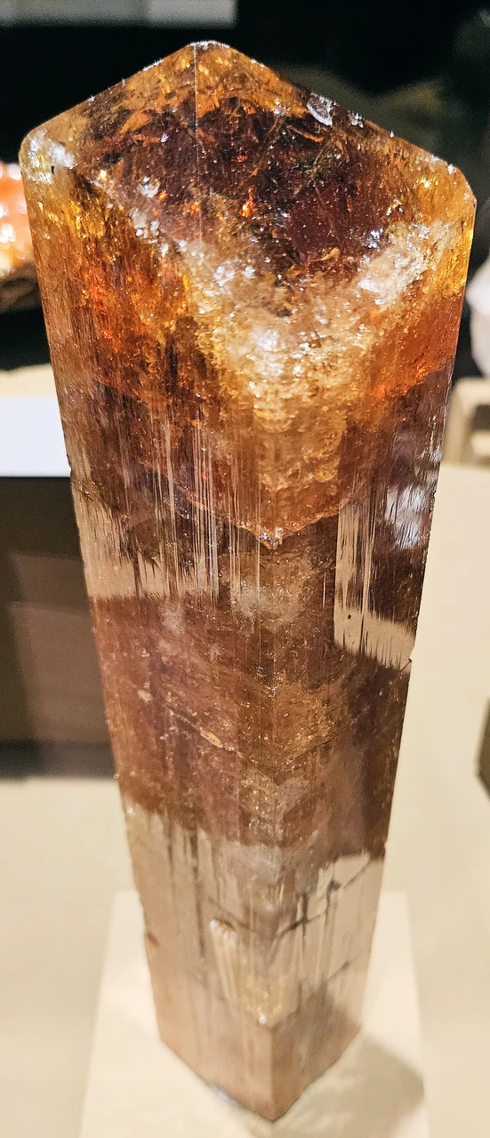 Orange-gold topaz crystal on museum display